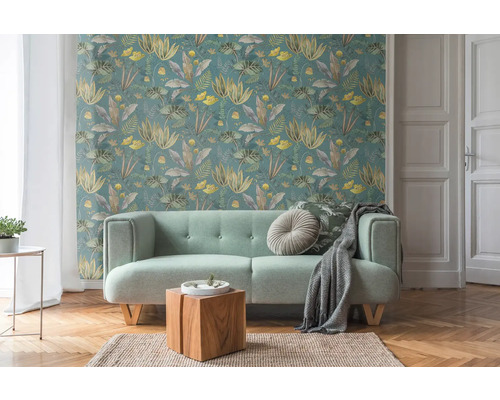 Vardagsrum med blommig tapet, soffa, träbord och matta