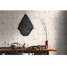 Dekorerat matbord framför en mönstrad tapet med blomdesign och en hängande lampa