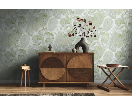 Vardagsrum med grön blad tapet, träskänk och dekoration