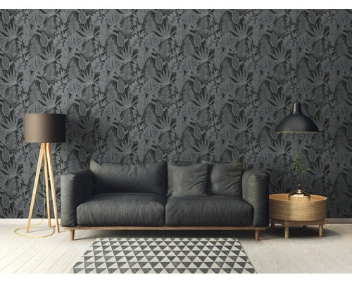 Vardagsrum med soffa framför mörk bladtapet