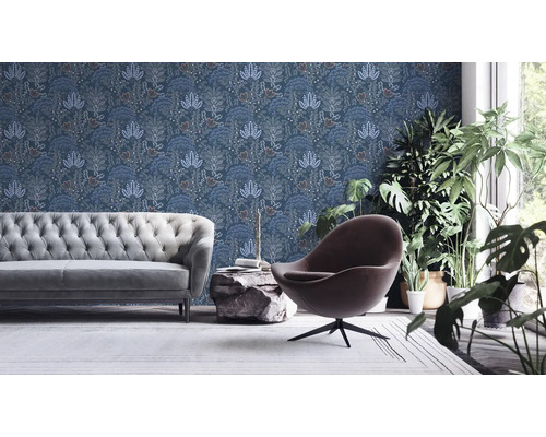 Vardagsrum med soffa, fåtölj, växter och mönstrad tapet