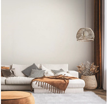 Ljust vardagsrum med soffa, kuddar, filt, lampa och dekoration