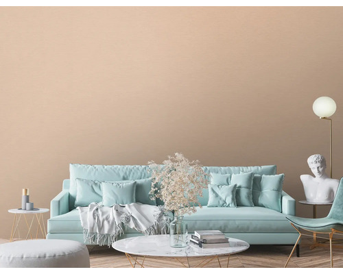 Vardagsrum med soffa, fåtölj, dekoration och beige väggbeklädnad.