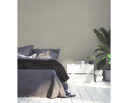 Sovrum med säng, sängbord och krukväxt för en ljus och vänlig atmosfär.