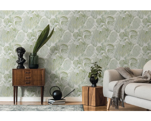 Vardagsrum med grön bladtapet, soffa och trämöbler