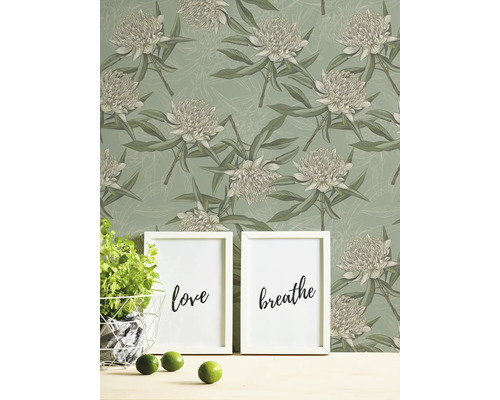 Blommig tapet med två bildramar, en kruka basilika och limefrukter