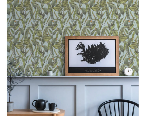 Scen med botanisk tapet med bladmönster och en inramad bild av Island