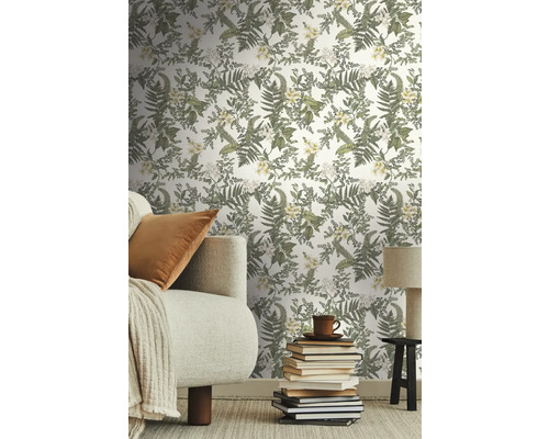 Vardagsrum med blommönstrad tapet, soffa, böcker och lampa