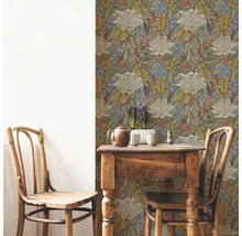 Rumsbild med blommönstrad tapet, träbord och två trästolar.