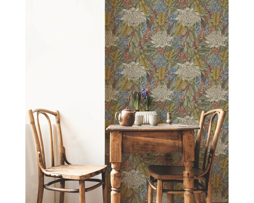 Rumsbild med blommönstrad tapet, träbord och två trästolar.