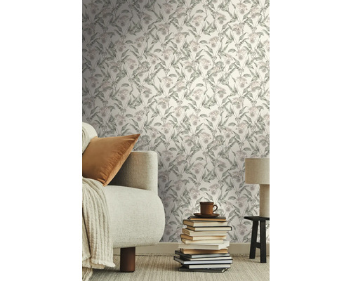 Vardagsrum med blommig tapet, soffa, kudde och trave med böcker som dekoration