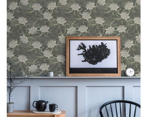 Vardagsrum med blommig tapet och en inramad bild av Island