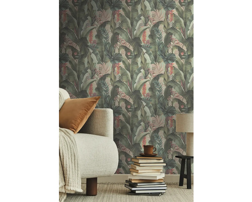 Vardagsrum med djungeltapet, soffa och bokstapel