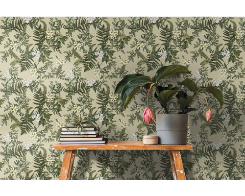 Scen med blommig tapet, böcker och krukväxt på ett bord