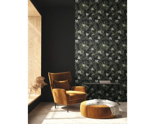 Vardagsrum med fåtölj, pall och blommig tapet för en mysig atmosfär