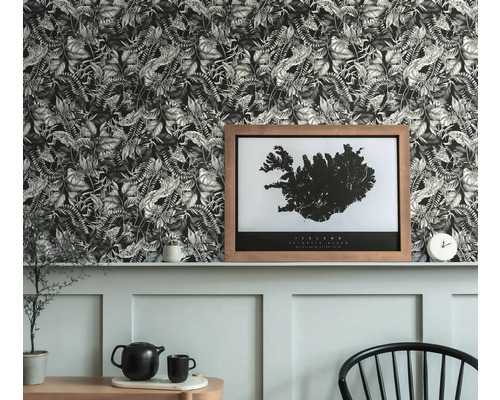 Rumsvy med mönstrad tapet, inramad tavla och dekorationer på en avsats