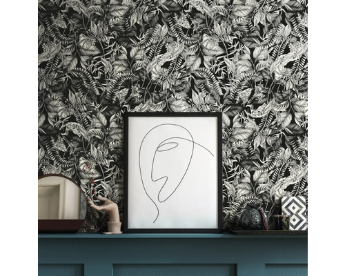 Dekorativ scen med blommig tapet, ram och heminredningsdetaljer på en hylla