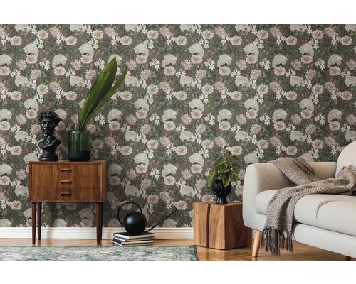 Vardagsrum med blommig tapet, soffa och trämöbler