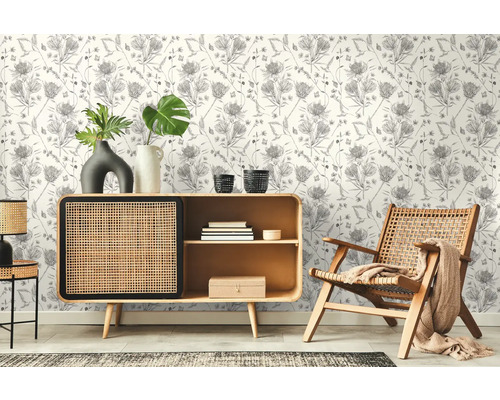 Vardagsrum med mönstrad tapet, byrå och trästol