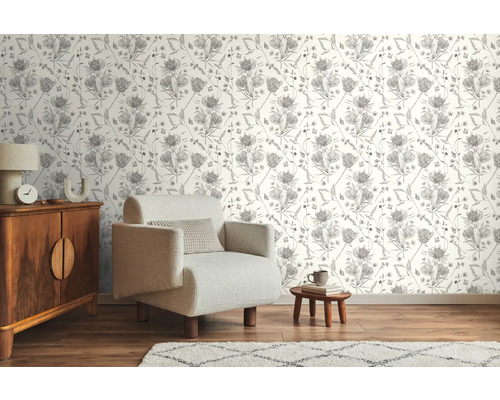 Vardagsrum med mönstrad tapet, fåtölj och träskänk