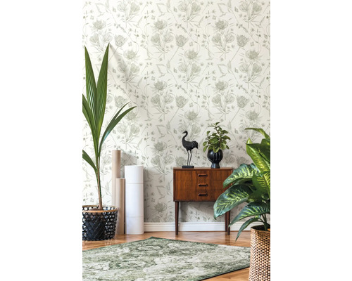 Dekorativt rum med mönstrad tapet, matta och trägolv.