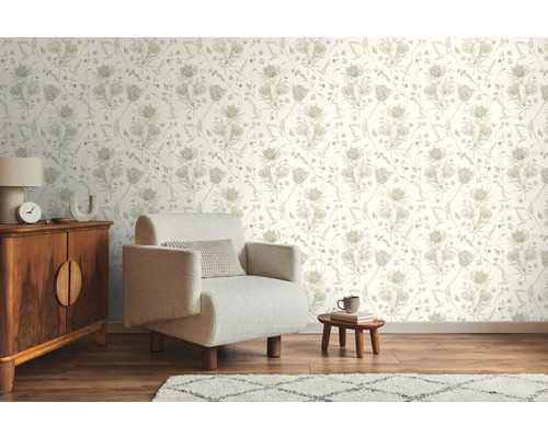 Inredningsexempel med blommig tapet, fåtölj, byrå och matta