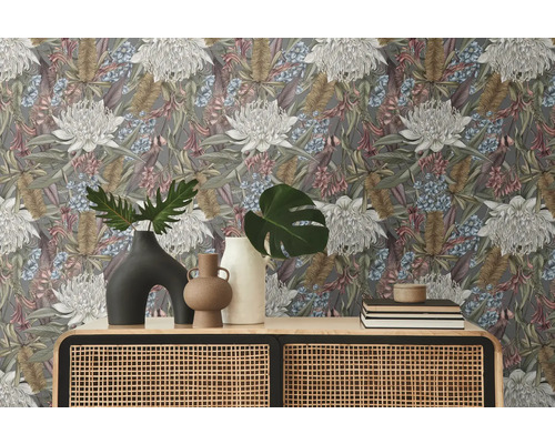 Rumsbild med blommönstrad tapet, byrå med rotting och dekorationer