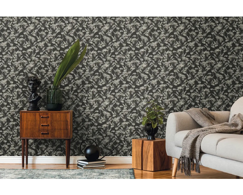 Dekorativt vardagsrum med blommig tapet, byrå och soffa.