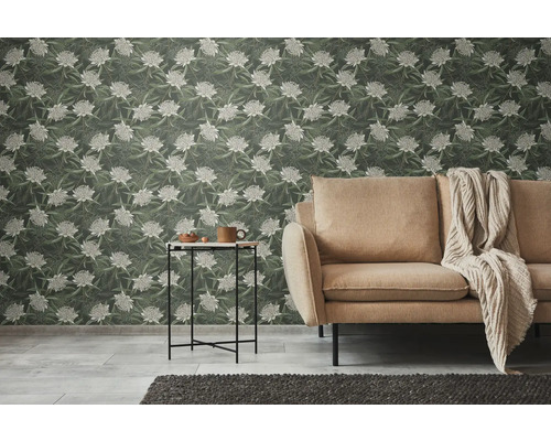 Vardagsrum med soffa, sidobord och blommig tapet