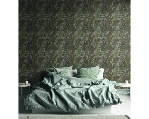 Sovrum med en säng och en vägg med blad-tapet
