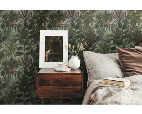 Sovrum med mönstrad tapet, sängbord och säng