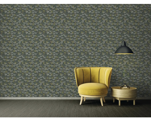 Dekorativt rum med blommönstrad tapet, fåtölj och lampa