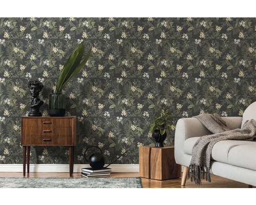 Vardagsrum med blommig tapet, byrå och soffa.