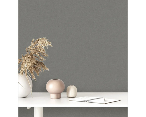 Dekorativ tapet i ett rum med vaser och skrivmaterial på ett bord