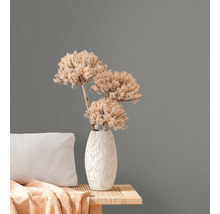 Närbild av grå non-woven tapet med blomsterarrangemang på ett sidobord