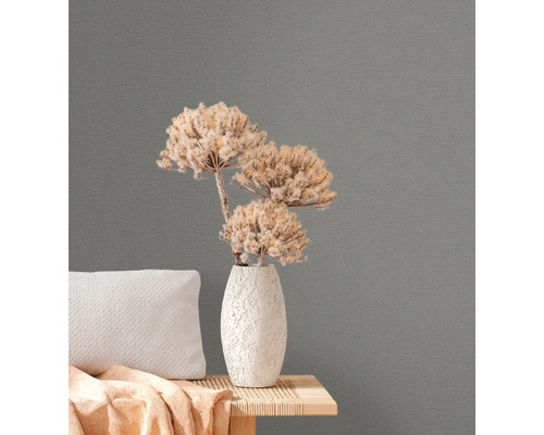 Närbild av grå non-woven tapet med blomsterarrangemang på ett sidobord