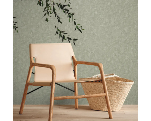 Scen med en fåtölj med träram, en beige sits och en korg framför en strukturerad vägg