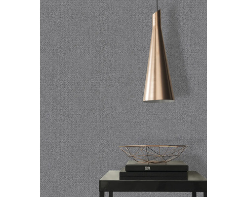 Närbild av en grå tapet med en fin struktur i ett rum med en lampa och dekorativa föremål.