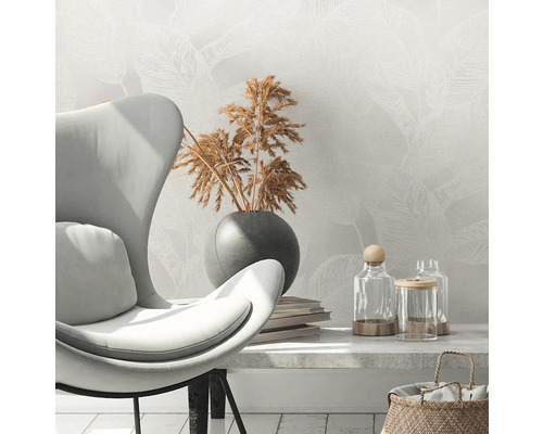 Scen med fåtölj, torkade blommor i vas, böcker och dekorativa glas