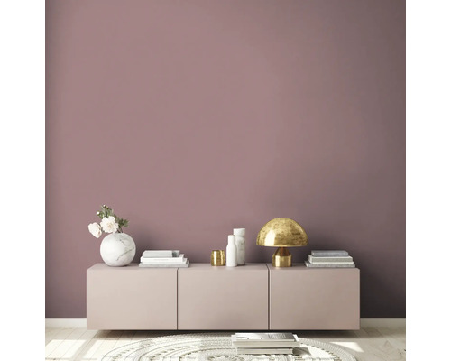 Vardagsrum med skänk, lampa och dekoration framför en vägg