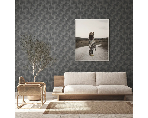 Vardagsrum med geometrisk tapet, soffa och inramad bild