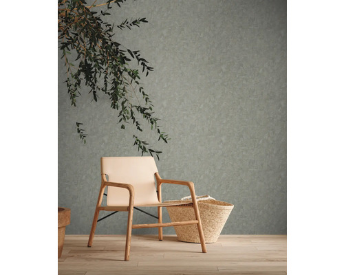 Vardagsrum med mönstrad tapet, fåtölj och korg