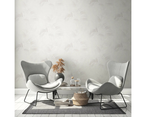 Vardagsrum med två fåtöljer, bord och mönstrad tapet