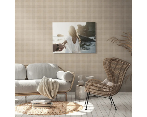 Vardagsrum med soffa, fåtölj och en canvasbild på väggen.