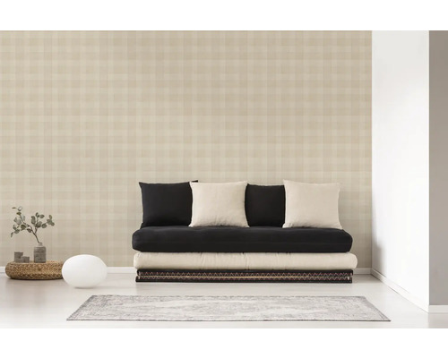 Vardagsrum med mönstrad tapet, futon, kuddar och dekorationer