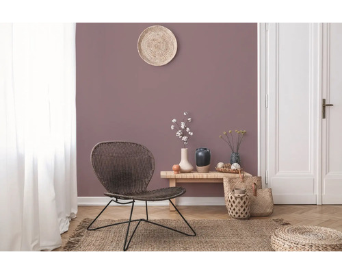 Vardagsrum med rottingfåtölj, träbord och dekorationer på en matta