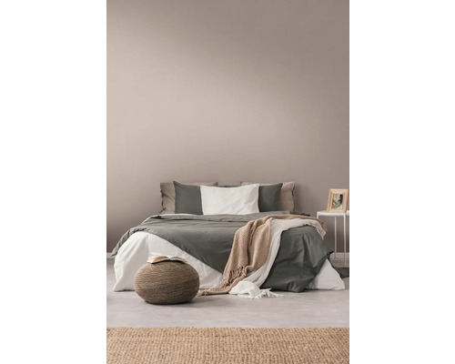 Sovrum med säng, sidobord, matta och sittpuff