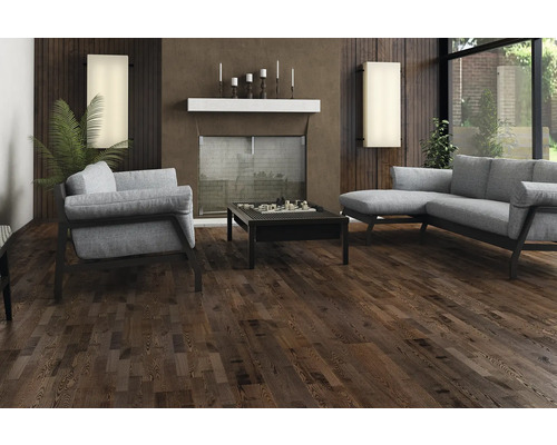 Vardagsrum med mörkt trägolv, soffa, fåtölj och soffbord