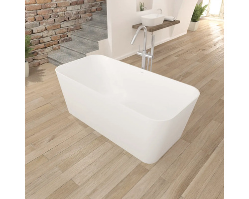 Fristående badkar i badrum med trägolv och handfat