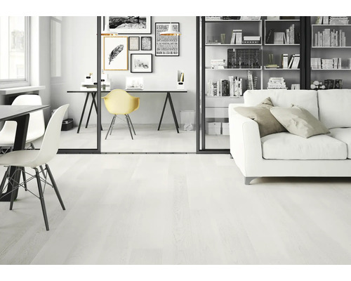 Ljust vardagsrum med trägolv, soffa, bokhylla och skrivbord